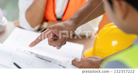 Green tech engineers analyzing plans for sustainable construction Green tech engineers analyzing plans for sustainable construction 132357222