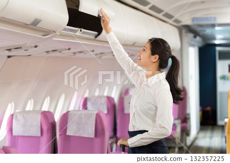 Business travel with a woman joyfully reaching for overhead bin on a flight 132357225