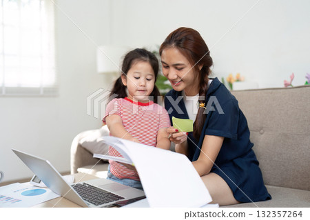 Family Time and Learning. A mother and daughter studying together, fostering creativity and bonding. 132357264