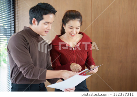 Business colleagues reviewing documents and discussing strategies Business colleagues reviewing documents and discussing strategies 132357311
