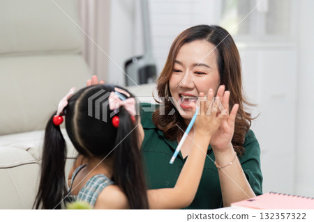 Back to School and Creative Learning. A mother and daughter high-five during a fun study session. 132357322