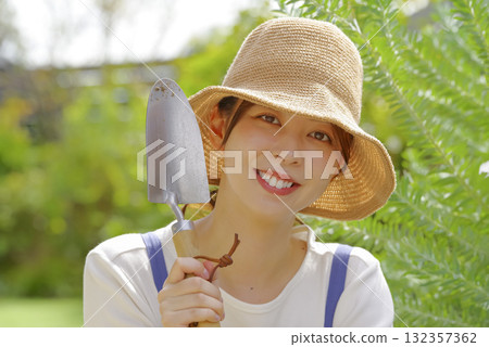 一名婦女用鏟子進行園藝 一名婦女用鏟子進行園藝 132357362