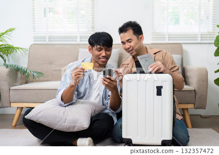 Travel Preparation and LGBT Couple. Two men excitedly organizing their travel essentials at home. 132357472