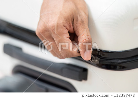 Zipping Up and Finalizing Luggage. A close-up of a hand zipping a suitcase, ready for the travel adventure ahead. Zipping Up and Finalizing Luggage. A close-up of a hand zipping a suitcase, ready for the travel adventure ahead. 132357478