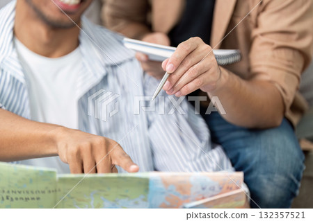 Planning a Trip Together. A couple joyfully discussing their travel itinerary over a map. 132357521