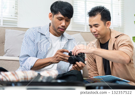 Travel Planning and Photography. A couple reviewing travel photos together, excited for their upcoming adventure. 132357522