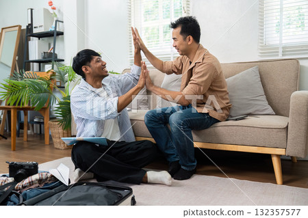 Couple Playing Together. Two partners engage in a playful moment while packing their travel items. 132357577