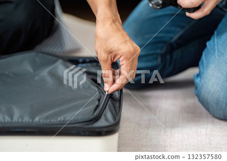 Couple Preparing for Travel. A loving couple packing their suitcase together for an upcoming trip. Couple Preparing for Travel. A loving couple packing their suitcase together for an upcoming trip. 132357580