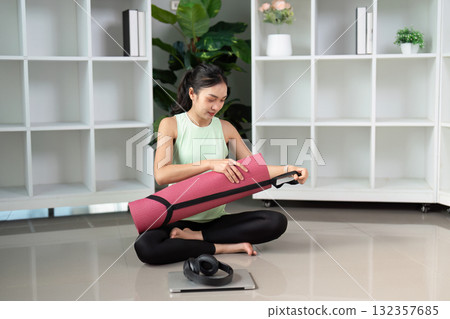 Wellness and Yoga Routine. A fitness enthusiast preparing her yoga mat ready for a stretching session at home. 132357685