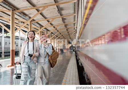 Travel Excitement and Exploration. Two women joyfully arriving at the train station ready for their next adventure. Travel Excitement and Exploration. Two women joyfully arriving at the train station ready for their next adventure. 132357744