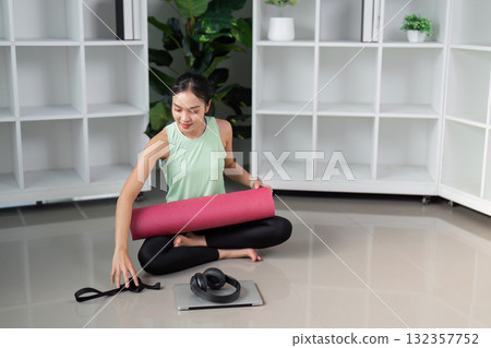 Preparation and Fitness Routine. A woman organizing her yoga gear, reflecting the importance of preparation in a wellness journey. Preparation and Fitness Routine. A woman organizing her yoga gear, reflecting the importance of preparation in a wellness journey. 132357752