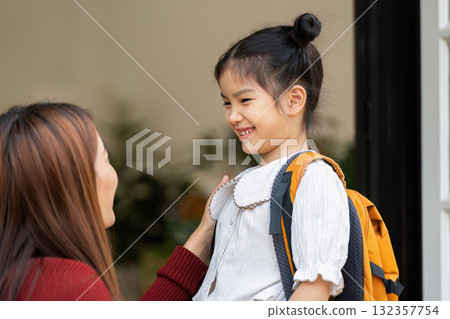 Confidence Boost Before School. A girl smiles brightly at a woman who supports her for the school journey ahead. 132357754