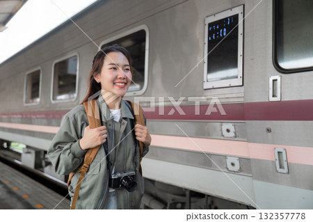 Travel and Adventure. A young woman joyfully awaits her train at the station, excited for the journey ahead. Travel and Adventure. A young woman joyfully awaits her train at the station, excited for the journey ahead. 132357778