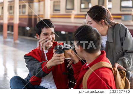 Cheers and Togetherness. Friends toast with coffee cups while waiting for their train, celebrating their journey. Cheers and Togetherness. Friends toast with coffee cups while waiting for their train, celebrating their journey. 132357780