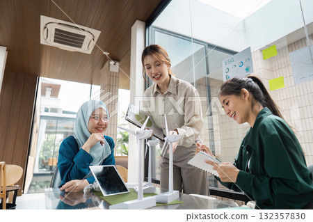 Team Collaboration and Sustainable Growth. A group discussing innovative sustainable technologies in a collaborative workspace. Team Collaboration and Sustainable Growth. A group discussing innovative sustainable technologies in a collaborative workspace. 132357830