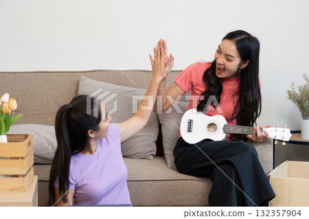 LGBT Connection and Home Joy. A couple celebrating their new home with music and high-fives. LGBT Connection and Home Joy. A couple celebrating their new home with music and high-fives. 132357904