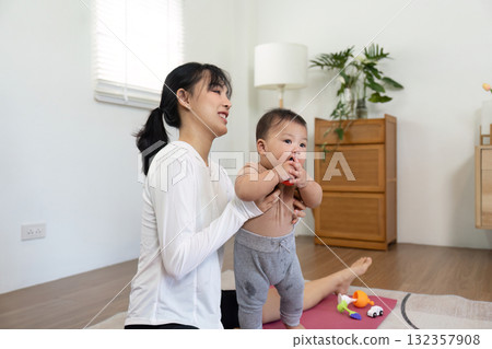 Support and Learning. A mother supporting her standing baby, emphasizing nurturing moments in play and development. Support and Learning. A mother supporting her standing baby, emphasizing nurturing moments in play and development. 132357908
