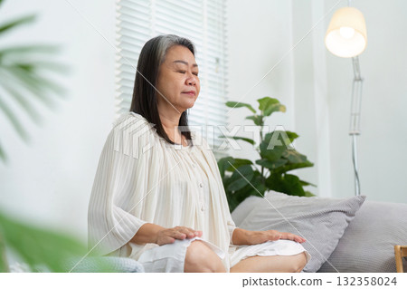 Meditation and Serenity. An elderly woman practicing meditation for wellness and inner peace. 132358024