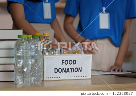 Food Donation Initiative. Volunteers organizing food donations in a community center. 132358037