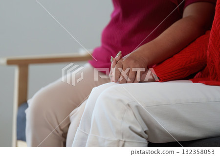 Tender Connection. Two women holding hands, symbolizing support and affection. Tender Connection. Two women holding hands, symbolizing support and affection. 132358053