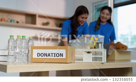 Donation Process. Volunteers preparing food donations in community center. 132358055