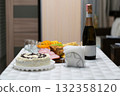 Festive table with a delicious cake, champagne, and snacks prepared for a celebration, symbolizing joy, hospitality, and special family or holiday moments 132358120