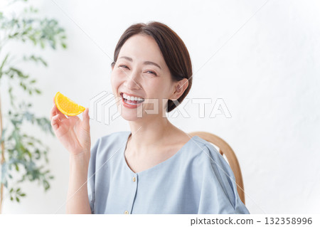 女人吃橘色水果 132358996