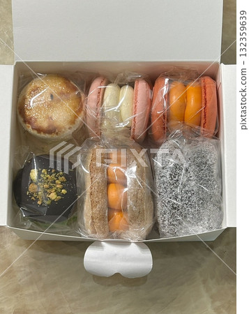 Colorful macarons with a delicate, crispy shell and soft, flavorful filling. Perfect for dessert photography, showcasing these elegant French treats in a variety of flavors and vibrant pastel colors. 132359639