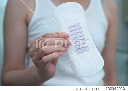 Asian woman holding sanitary napkin pad for hygiene menstrual period cycle protection. Asian woman holding sanitary napkin pad for hygiene menstrual period cycle protection. 132360020
