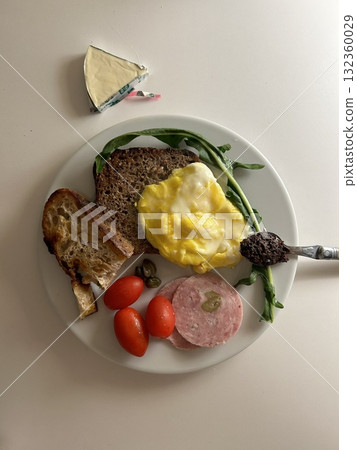 A delightful brunch spread featuring a mix of savory and sweet bites. perfectly toasted bread, fresh fruits, soft scrambled eggs, and a refreshing drink to brighten your late morning. 132360029