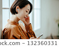 A woman in her 40s wearing wireless earphones 132360331