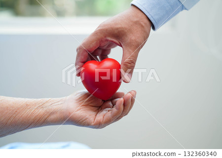 Asian elder senior woman patient holding red heart in hospital. Asian elder senior woman patient holding red heart in hospital. 132360340