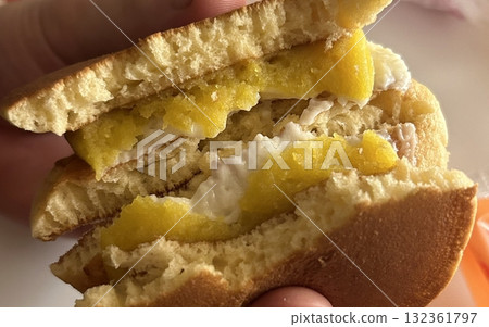 Soft and fluffy dorayaki pancakes filled with sweet red bean paste, creating a delicious Japanese treat perfect for snacking or dessert. 132361797