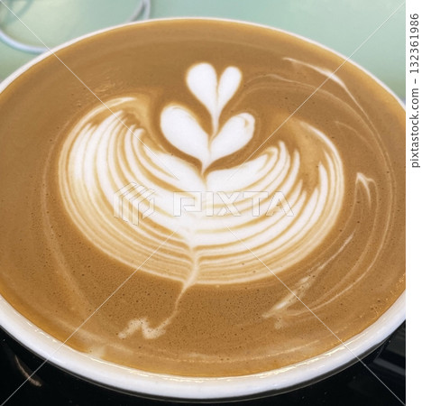 A beautifully crafted latte, featuring creamy foam art on top of rich espresso. Perfect for coffee-related projects, this image captures the warmth and inviting nature of a classic café experience. 132361986