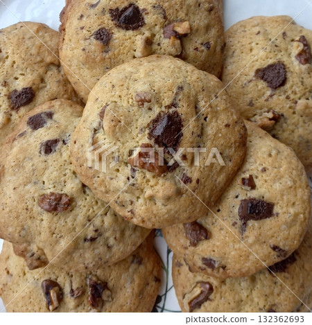 Freshly baked cookies with a golden-brown finish and chocolate chips. Perfectly crisp on the edges with a soft center, offering a delicious, comforting treat for any occasion. Freshly baked cookies with a golden-brown finish and chocolate chips. Perfectly crisp on the edges with a soft center, offering a delicious, comforting treat for any occasion. 132362693