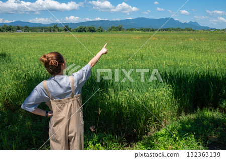 Rear view of woman pointing to Doi Nang Non mountain ( the Mountain of the Sleeping Lady) an iconic mountains range located in Mae Sai district of Chiang Rai province, Thailand. Rear view of woman pointing to Doi Nang Non mountain ( the Mountain of the Sleeping Lady) an iconic mountains range located in Mae Sai district of Chiang Rai province, Thailand. 132363139