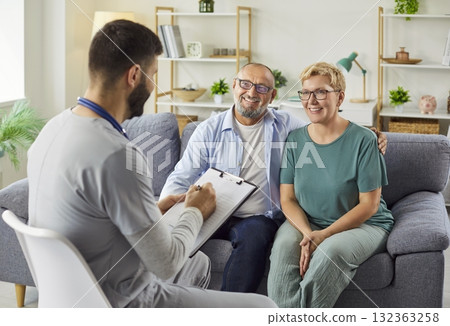 Home health visit with doctor consulting a smiling senior couple at home. Home health visit with doctor consulting a smiling senior couple at home. 132363258