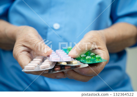 Asian elderly woman holding pill drug in hand, strong healthy medical concept. 132364522