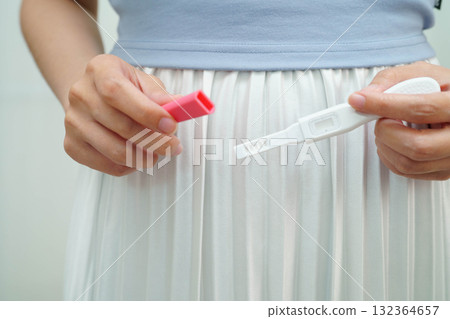 Asian holding pregnancy test for female of ovulation day, fetus, maternity, childbirth, birth control. Asian holding pregnancy test for female of ovulation day, fetus, maternity, childbirth, birth control. 132364657
