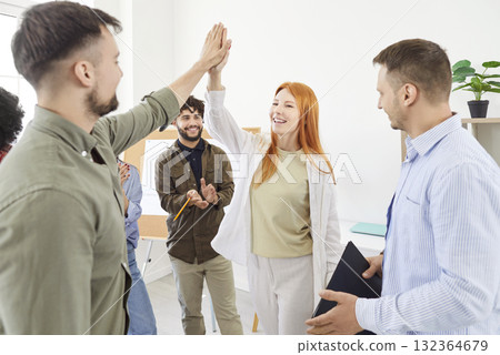 Happy colleagues giving high five at meeting in office, celebrating success or business achievement 132364679