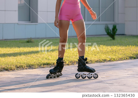 Legs of woman in sportswear rollerblading outdoor on a sunny day Legs of woman in sportswear rollerblading outdoor on a sunny day 132365430