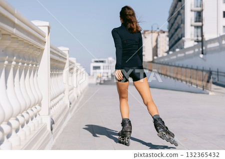 Active woman rollerblading outdoors in black sportwear, active lifestyle 132365432
