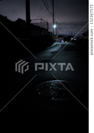Night road after the rain and manhole illuminated by streetlight (vertical position) 132367575