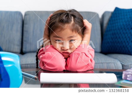 Elementary school girl holding her head 132368158