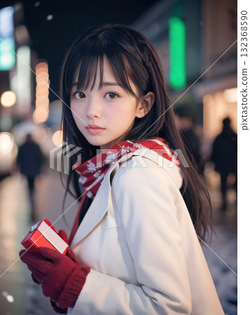 在閃閃發光的聖誕燈的雪夜裡,微笑的年輕女子手裡拿著禮物 在閃閃發光的聖誕燈的雪夜裡,微笑的年輕女子手裡拿著禮物 132368590