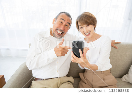 Senior couple surprised at their smartphone 132368888