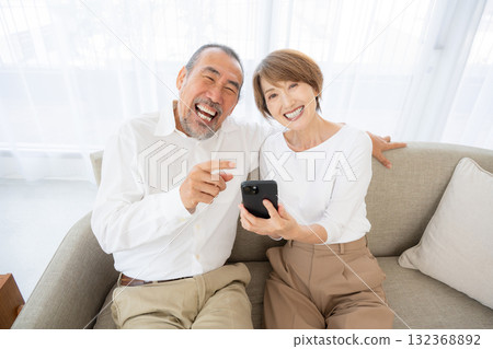 老年夫婦一邊操作智慧型手機一邊大笑 132368892