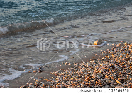 Pebbles and sea detail in the sunset, Greece 132369896