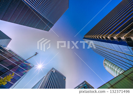 A rare sight in the cityscape of Yokohama, Japan. A mysterious sight of a pale ring surrounding the sun... View of the skyscrapers in front of Shin-Takashima Station 132371496