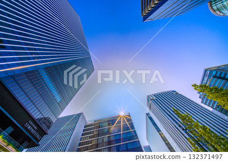 A rare sight in the cityscape of Yokohama, Japan. A mysterious sight of a pale ring surrounding the sun... View of the skyscrapers in front of Shin-Takashima Station 132371497